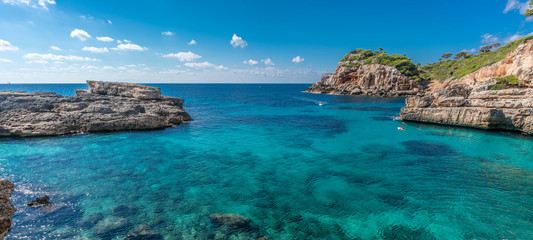 Panoramic view of crystalline turquoise waters of Cala s'Almunia beach from cap des moro. Located...