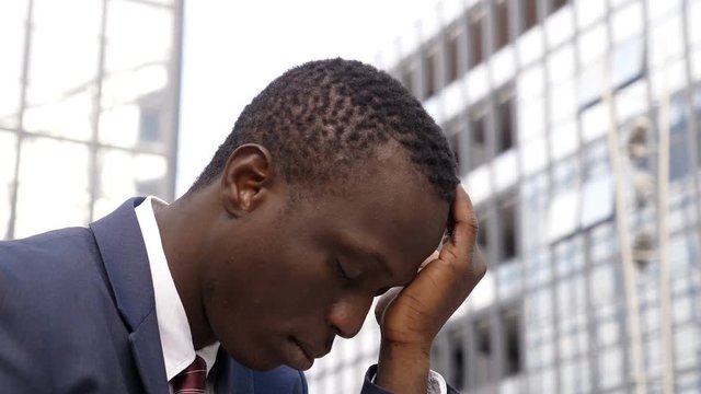 Sad and depresssed black american business man in teh city- profile