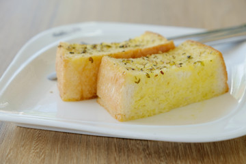 Delicious Garlic bread on white plate.