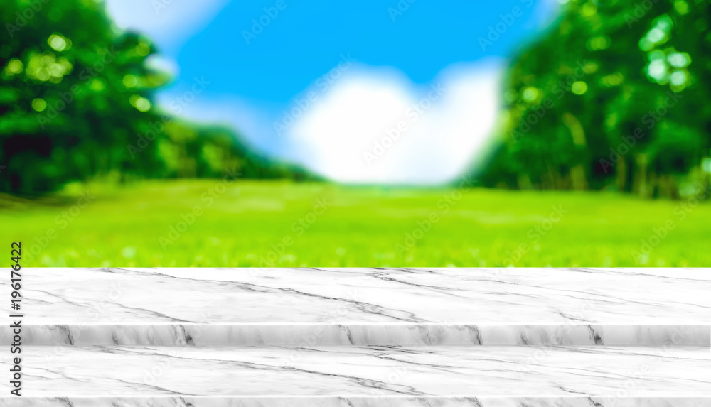 Aufkleber Empty white marble table top with blur grass field in park with bokeh light at background,Mock up template for display of your design,Banner for advertise of product,panorama view