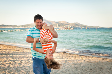 3255739 Father playing with his daughter on the evening beach