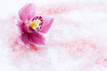 Spa and wellness setting with orchid and rose sea salt on wooden white background closeup