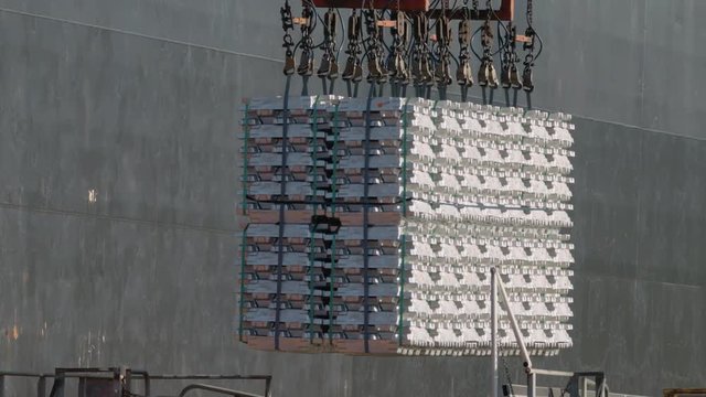 Telephoto shot of aluminum ingots being loaded onto a ship for export from Australia - 4K 30P. 