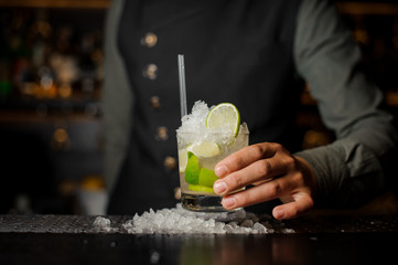 Barman hand holding a glass with a fresh mojito