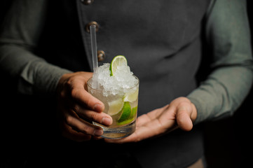 Barman holding a glass with a fresh mojito
