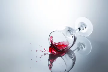 Photo sur Plexiglas Vin Red wine spilled out of a falling glass with reflection on the surface