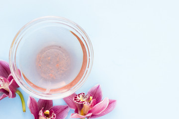 Spa and wellness setting with orchid and oil on blue background copyspace