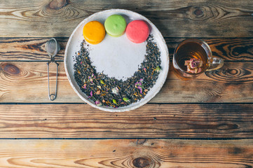 Tea with rose-petals and macaroons on a wooden table. Vintage composition. Top view