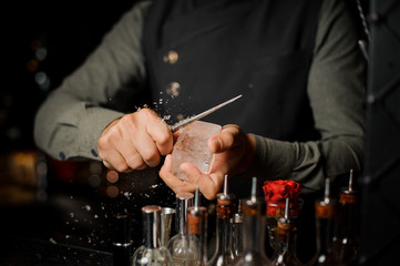Barman preparing a large rectangular piece of ice
