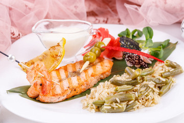 Steak from salmon with a side dish of rice and green beans.