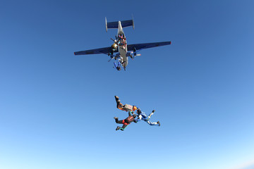 Skydivers are jumping out of a plane.