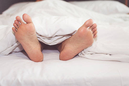 Woman on the bed at home with their feet showing