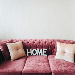 Soft comfortable sofa. Hygge. Home. Pink sofa made of velour. Copy space.