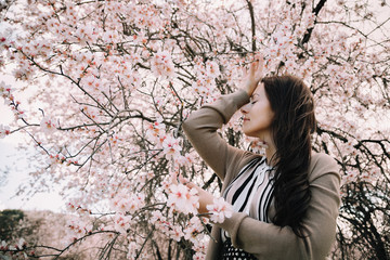 girl in a garden with blooming almonds