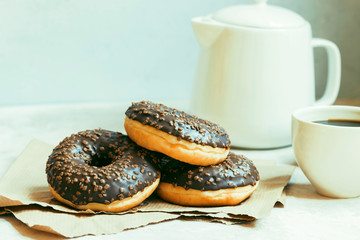 Chocolate donuts and coffee , weekend morning table breakfast. Vintage colors.