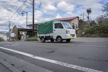 Fototapeta na wymiar 田舎道路の軽トラック