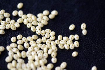 Scattered twin beads green color on a dark surface close up