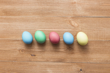 Happy easter eggs on color for holiday on wooden background top view flat lay