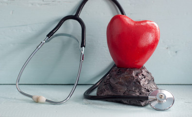 close - up of red heart and stethoscope on blue background,