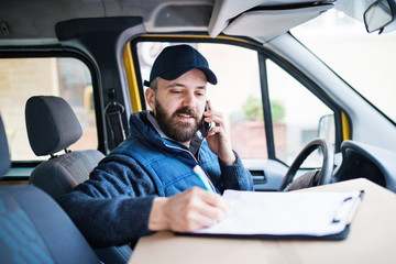 Delivery man delivering parcel box to recipient. © Halfpoint