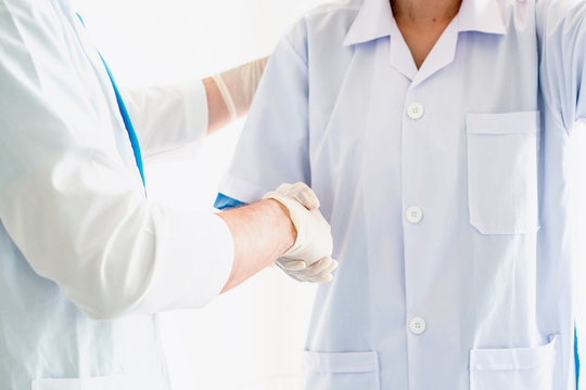 Two medical workers make handshake