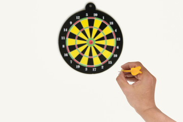 Human hand is throwing the darts target to the darts board