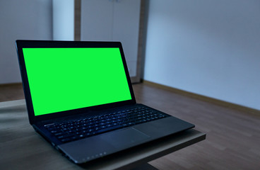 laptop on desk with green screen