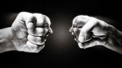 Two fists with a male and female face collide with each other on dark background. Concept of...