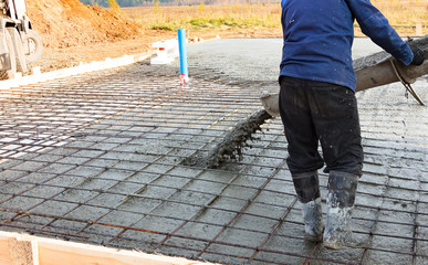 Closeup shot of concrete casting on reinforcing metal bars of floor in industrial construction site