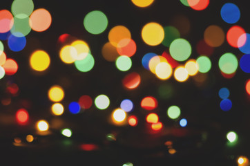 Colored blurred lights on dark background. Bokeh, soft focus