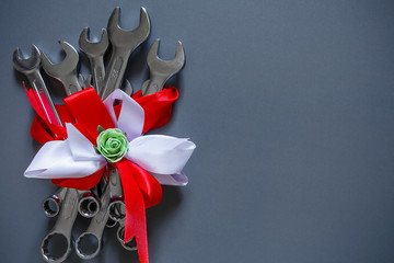 A set of tools of wrenches for repair on a gray background in festive packing bouquets copy space...