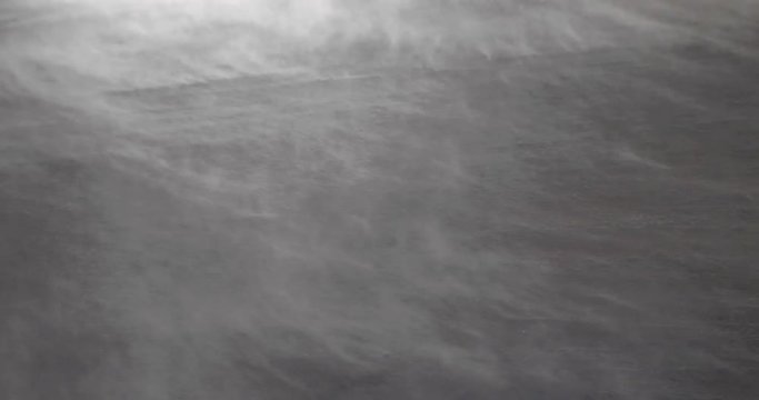 Mighty blizzard is blowing snowflakes in a winter night
