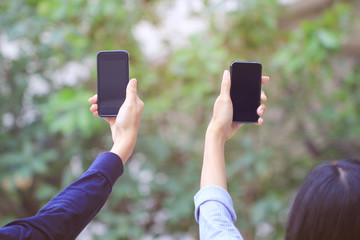 Two teen girls hand holding smartphone with blank screen