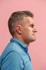 Obraz premium Suspiciont. Doubtful pensive man with thoughtful expression making choice against pink background
