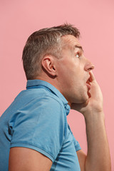 Obraz premium The young attractive man looking suprised isolated on pink