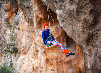 The climber is hanging on a rope.