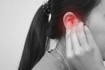 Fototapeta premium Tinnitus, young woman has pain in the ear