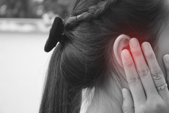 Tinnitus, young woman has pain in the ear