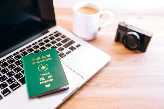 Taiwan Passport, Computer And Camera On Wood Table