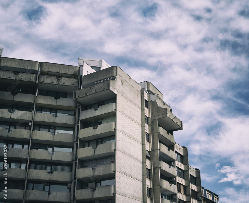 Wall mural Residential building made in brutalist high-tech architecture style - house is made of grey conrete. Retro filter simulation