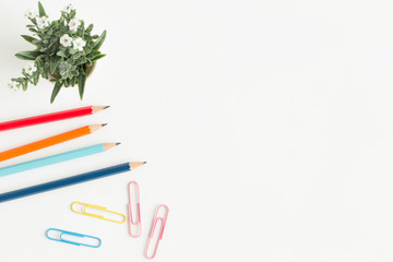 Flat lay photo of office desk with colorful pencil and paper clip,copy space top view
