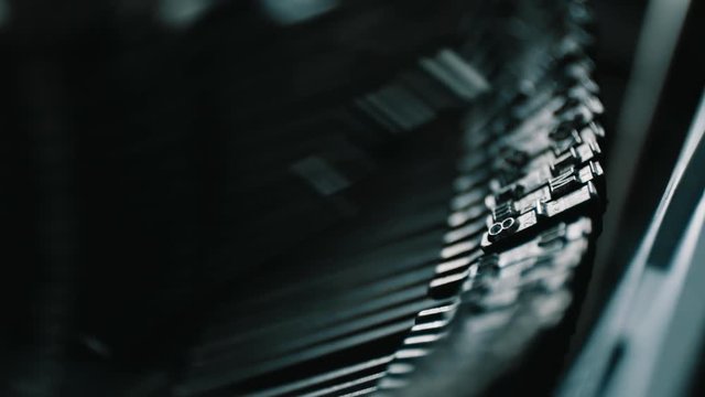 Slow motion closeup shot of detail of vintage typewriter metallic letters