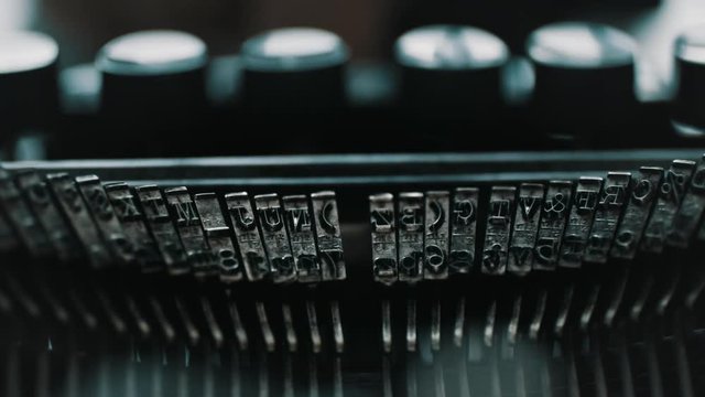 Slow motion closeup shot of detail of vintage typewriter metallic letters