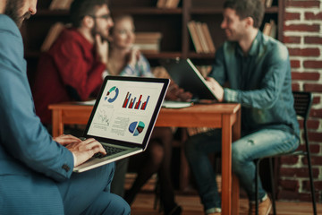 Manager Finance works with the marketing graphics on the laptop