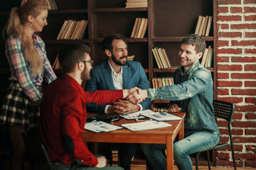 business partners shake hands after discussing the contract at t