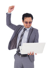 winner business man holding laptop with arms raised isolated on white background