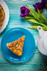 Pumpkin pie on a blue background with a teapot and flowers