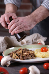 The man peppers the food