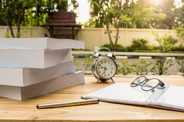 Desk on the balcony with a notepad book watches glasses and pen on the table