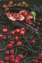 Collection of fresh purple and red fruit and vegetables on the black vintage color